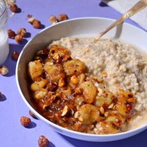 Caramelized bananas on top of oatmeal with a purple background.