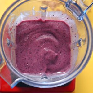 Overhead image of blended purple smoothie bowl in a blender.