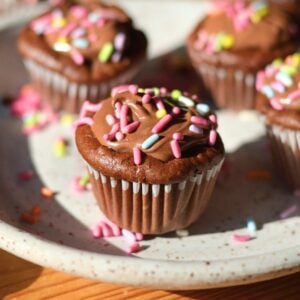 A protein chocolate cupcake with sprinkles on the plate.