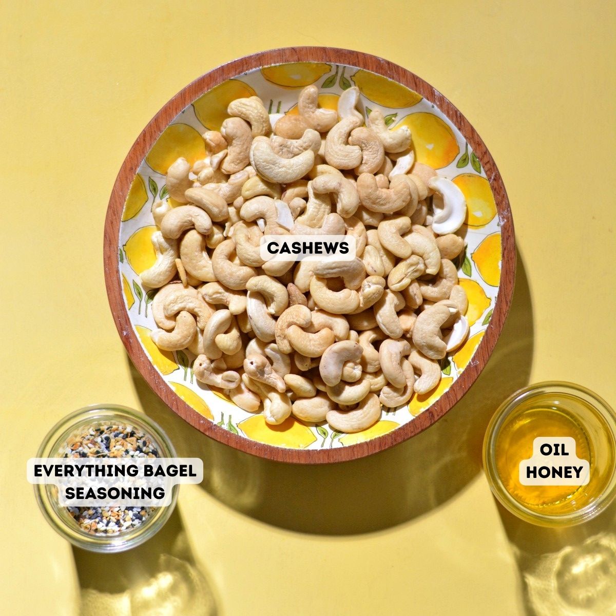 Ingredients for everything bagel cashews including raw cashews, everything bagel seasoning, honey, and oil.