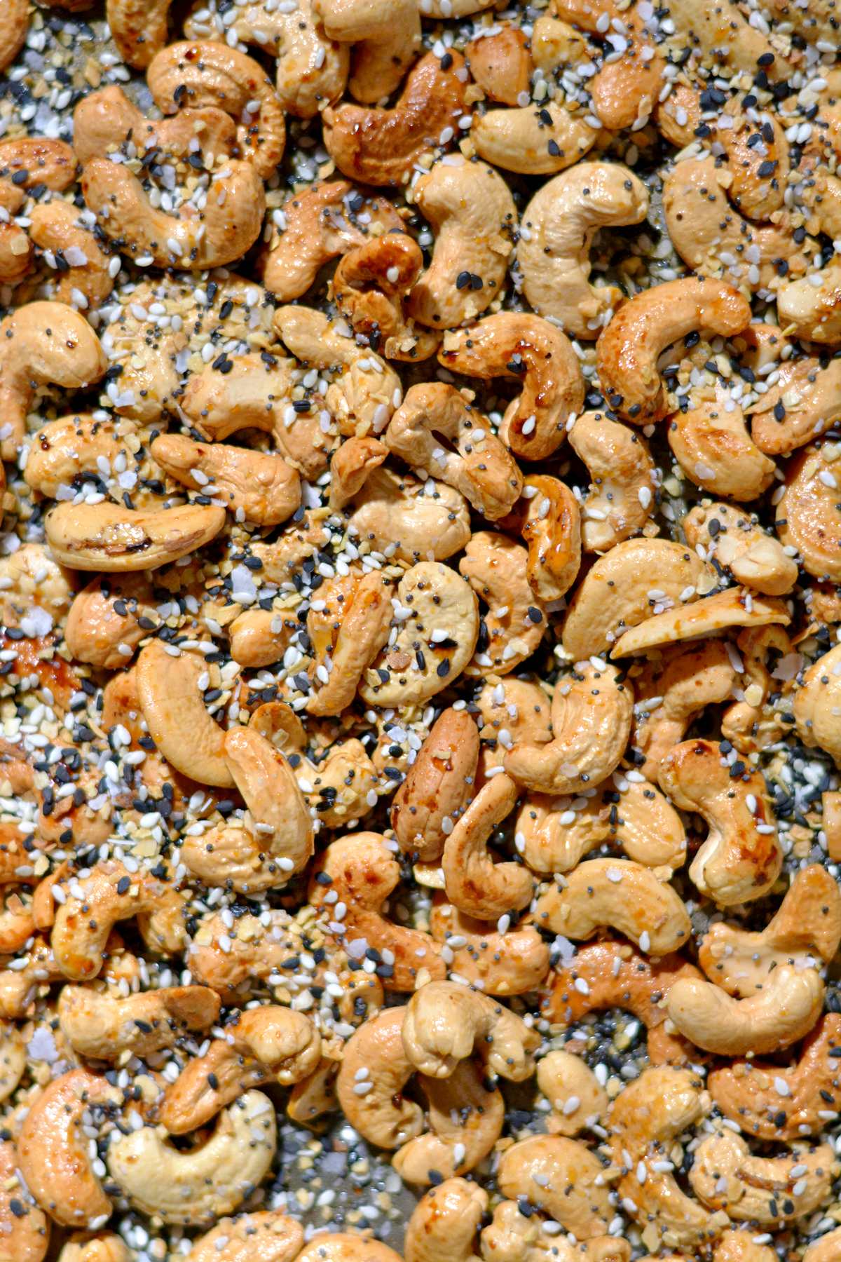Close up of cashews on a tray with everything seasoning.