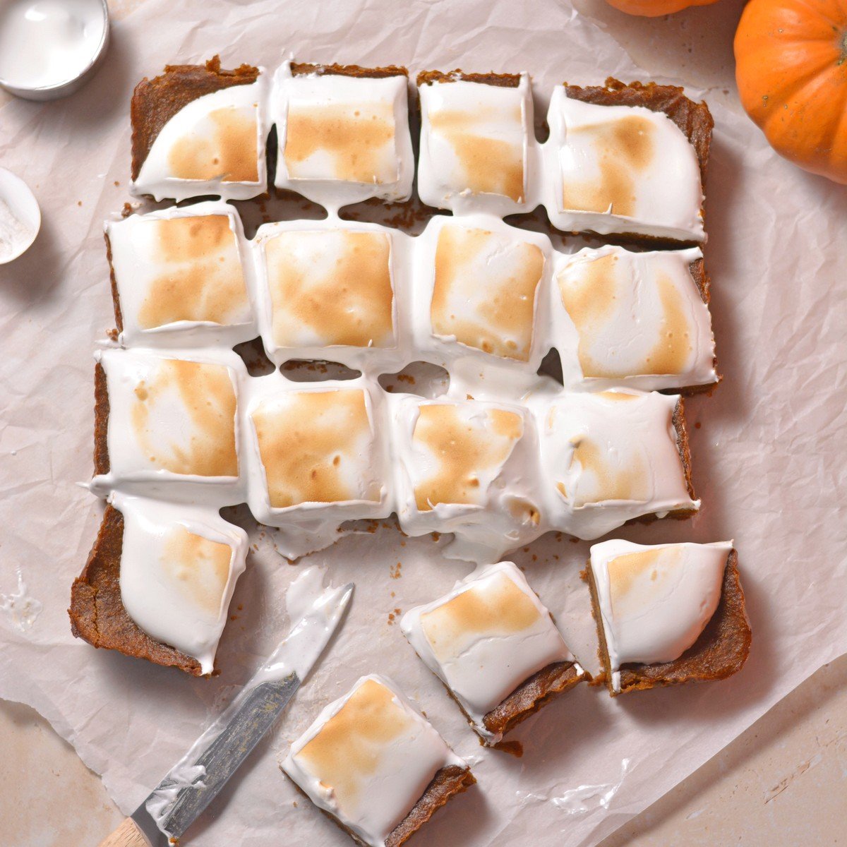 Pumpkin pie bars sliced into 16 even bars with toasted meringue topping.
