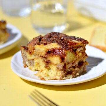 A slice of protein french toast casserole with sausage on a plate.