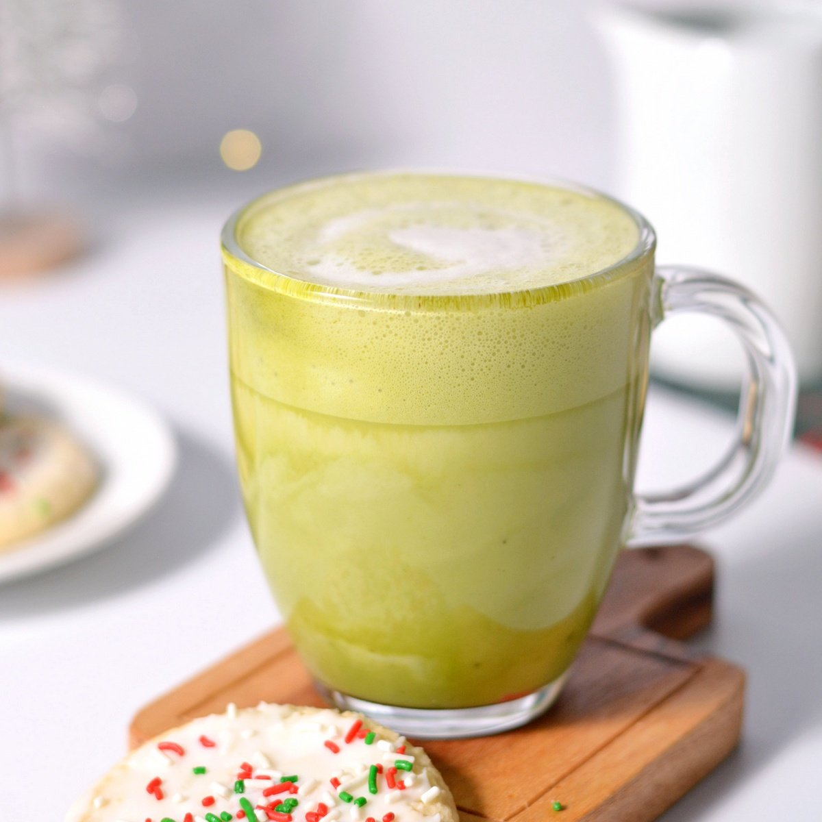 A cup of matcha next to a sugar cookie.