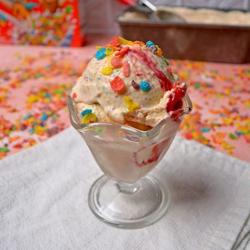 Fruity Pebble Ice Cream in Glass sundae cup and sitting on a white napkin.