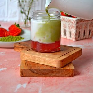 Strawberry Matcha Latte being poured into a glass mason jar
