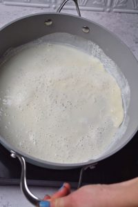 Spreading egg white mixture around pan.