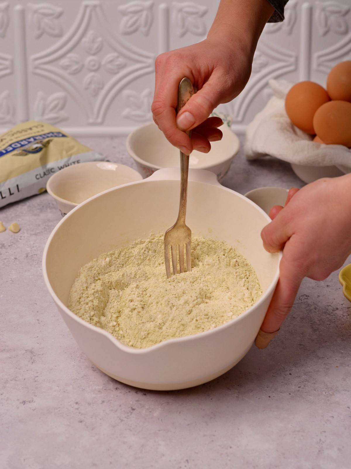 Mixing a bowl of dry ingredients with a fork.