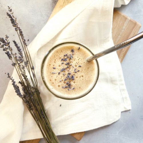 Overhead view of a coffee drink with lavender buds on top.