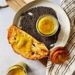 Toast with jam on a plate that has chia seeds and jam in a mason jar.