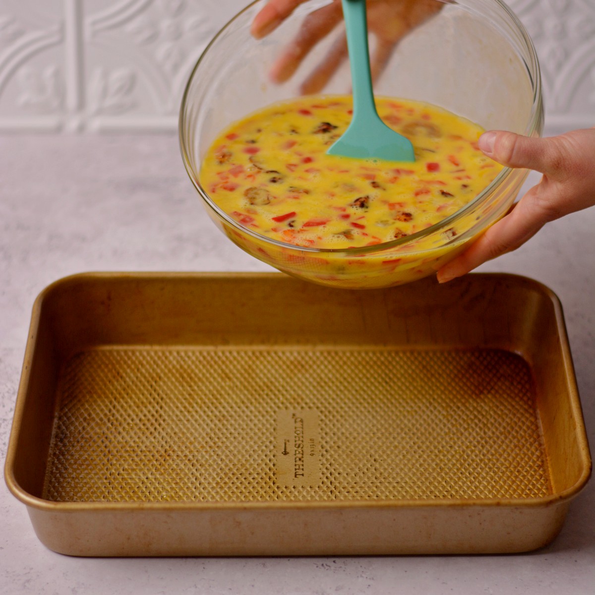 step 4 bowl with egg mixture being poured into baking pan.
