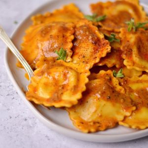 A close up of a pile of ravioli coated in a creamy brown sauce.