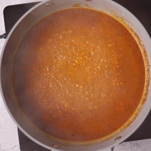 Overhead view of a brown sauce in a pan.