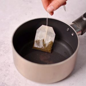 A tea bag in a pot of water.