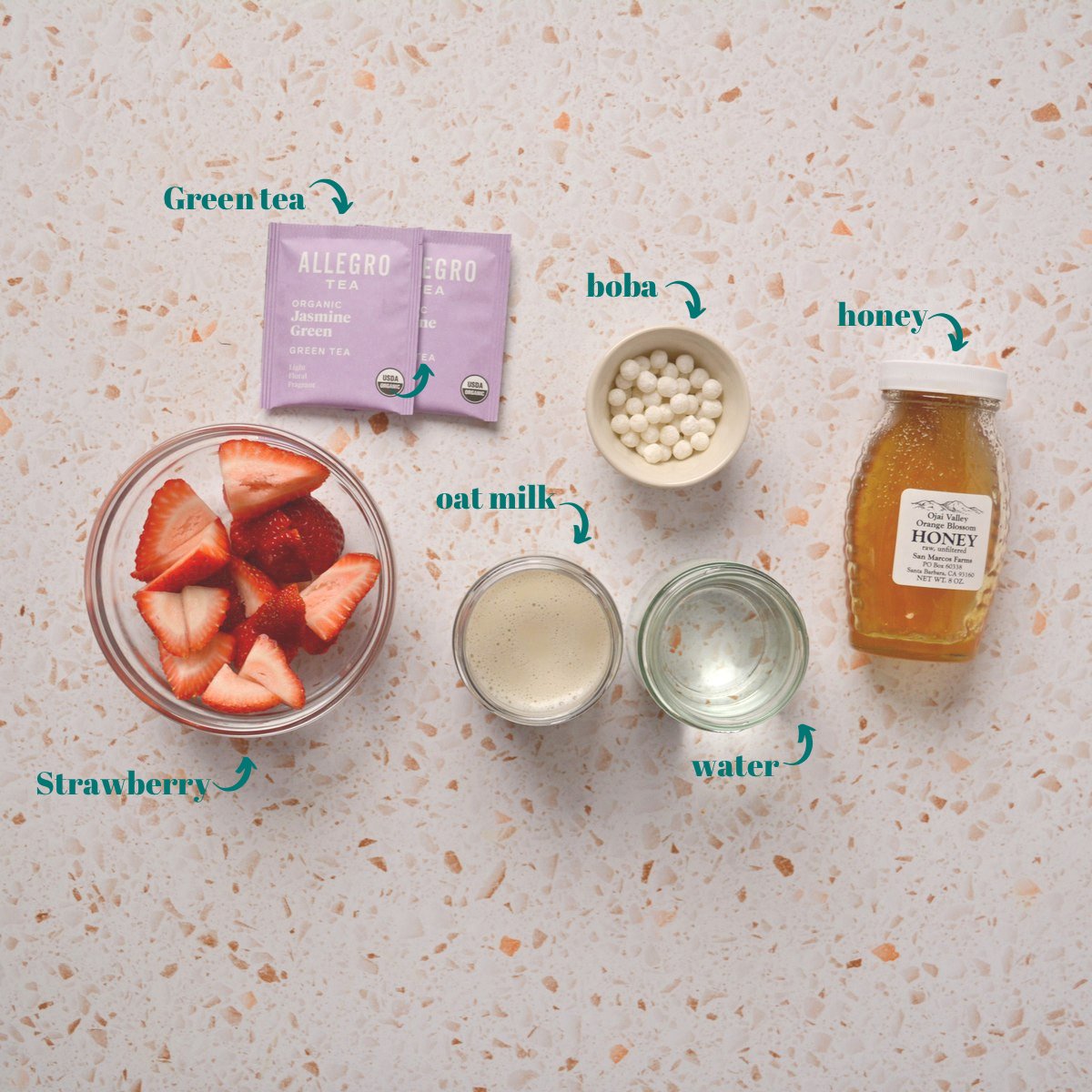 Overview of tea, strawberries, honey, water, milk, and tapioca pearls.