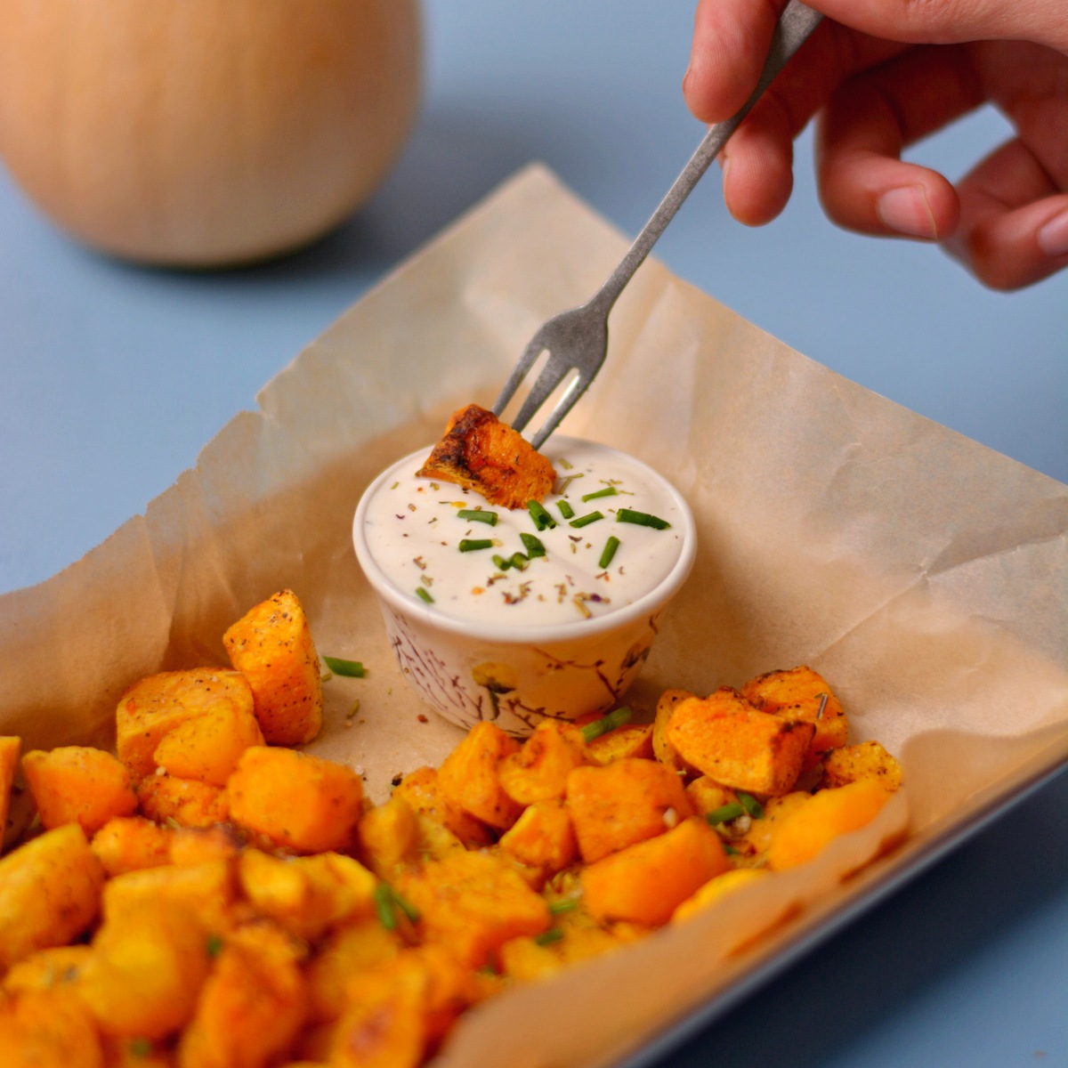 A fork dipping a butternut squash cube into ranch dressing.