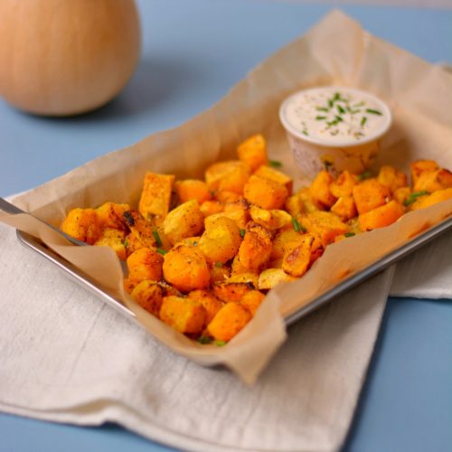 Butternut squash cubes in a tin with a cup of ranch.
