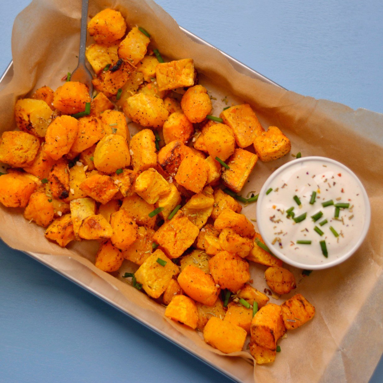 Overhead view of butternut squash cubes in a tray.