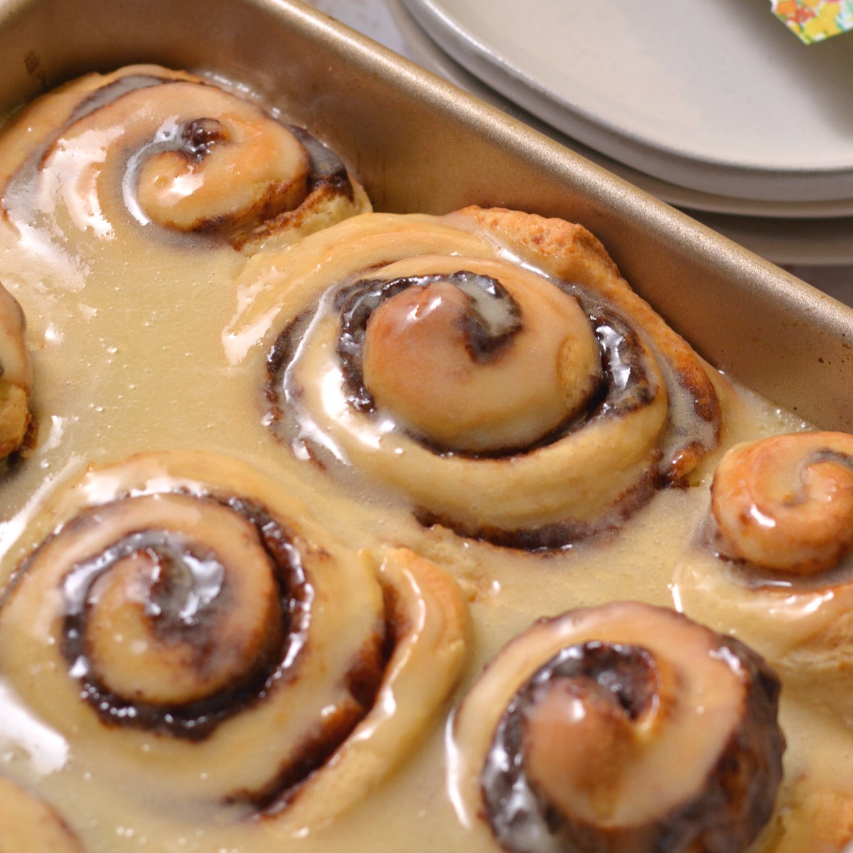 Protein cinnamon rolls in a pan with icing.