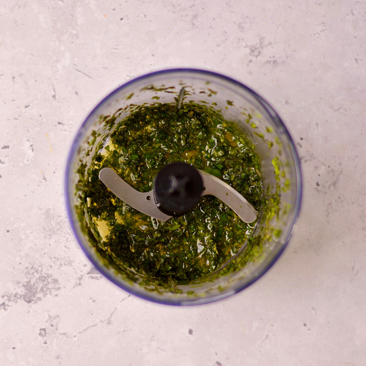Basil and oil blended in a food processor.