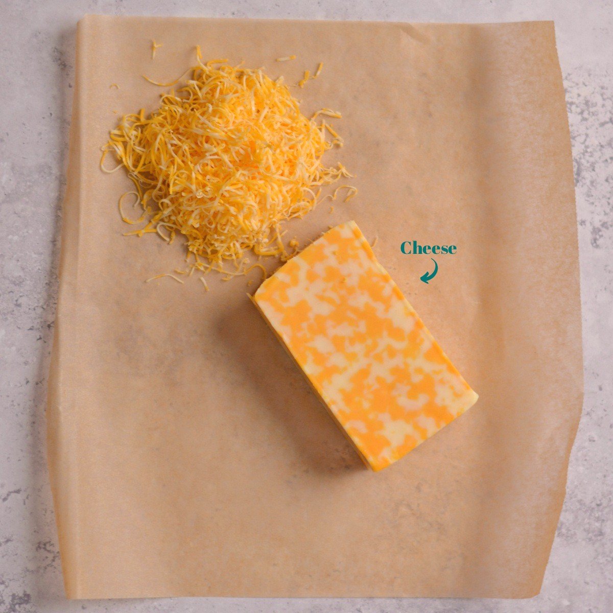 Photo of a cheese block next to shredded cheese.