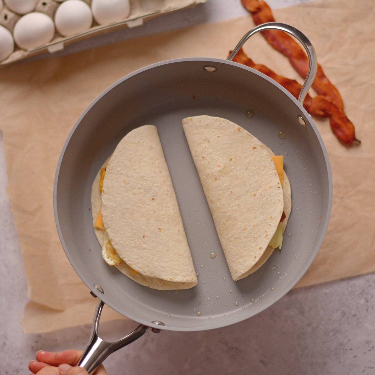 Two tortilla wraps in a frying pan.