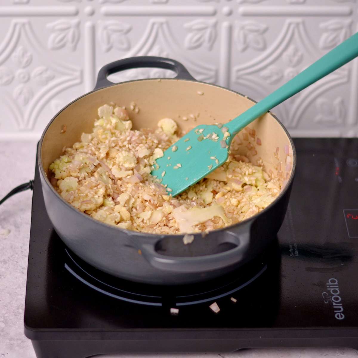 Rice and cauliflower cooking in a Dutch oven.