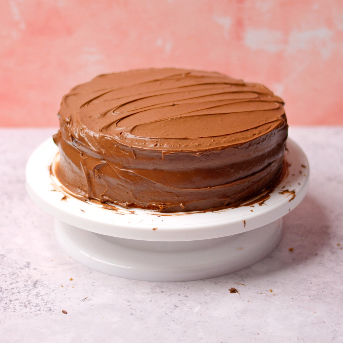 Chocolate frosting spread on a round cake.