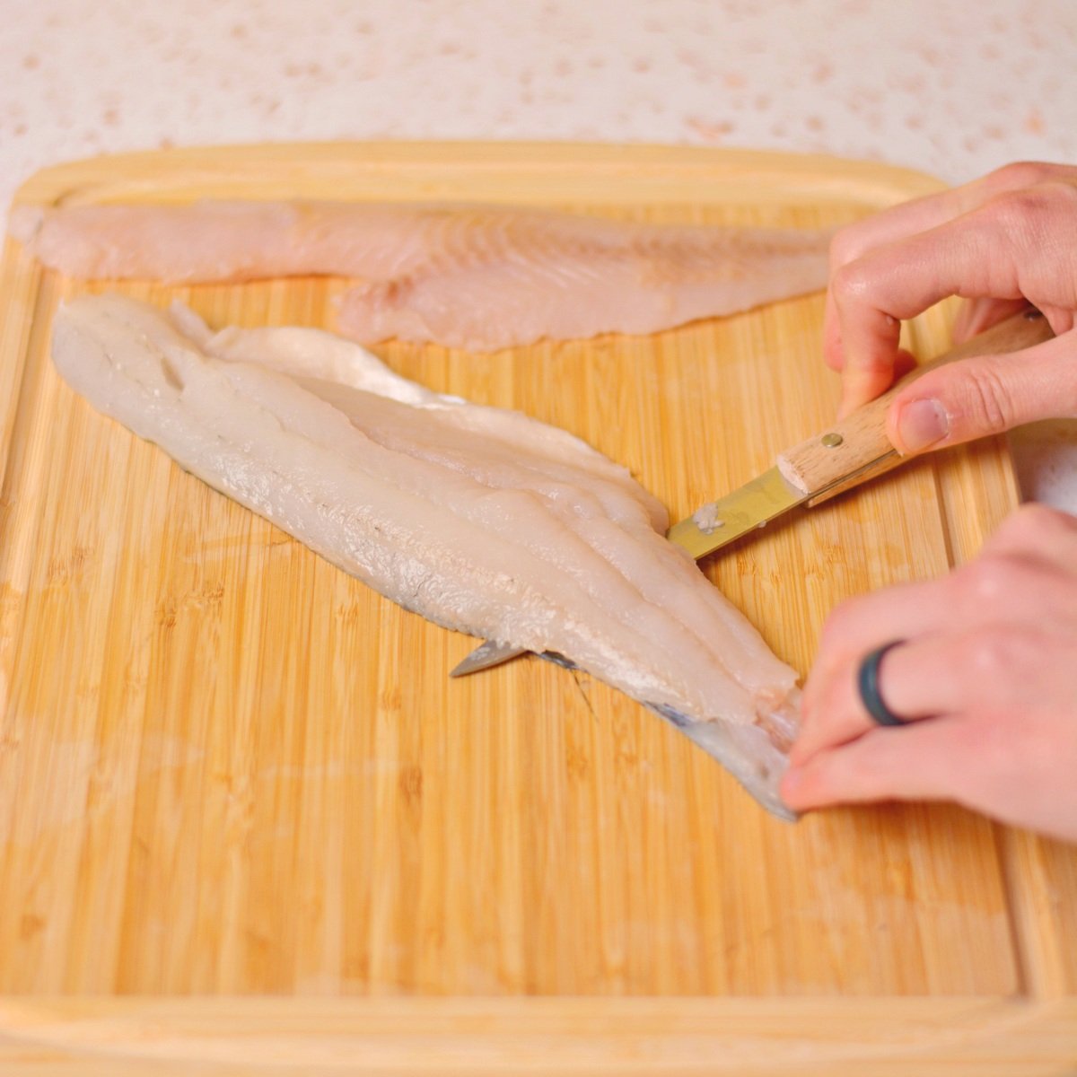 Cutting the skin off of a walleye fillet.