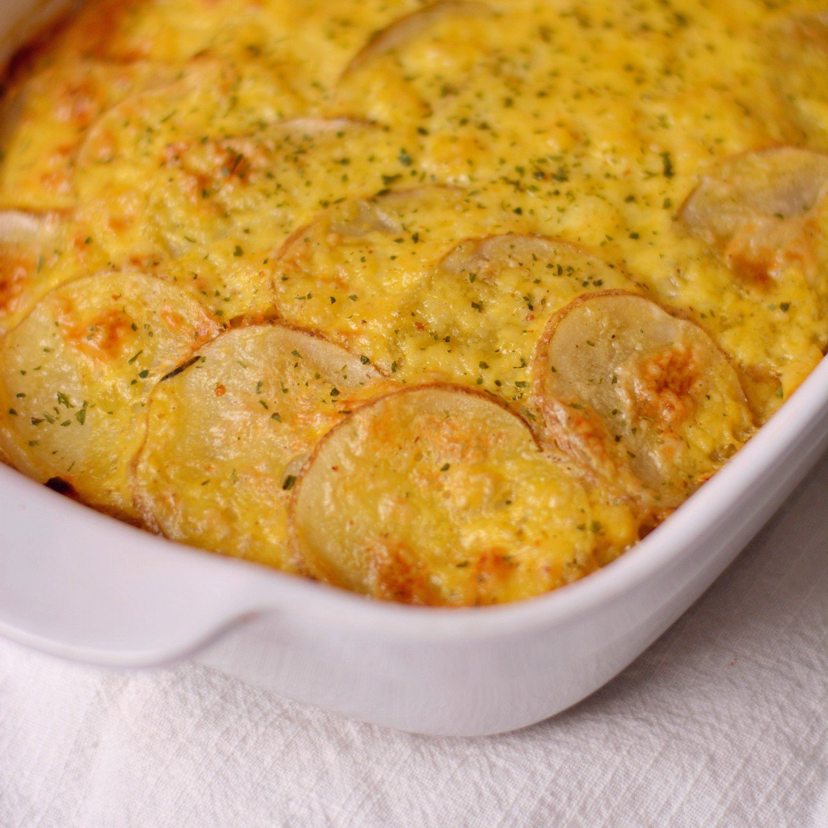 Scalloped potatoes without cream in a white casserole dish.