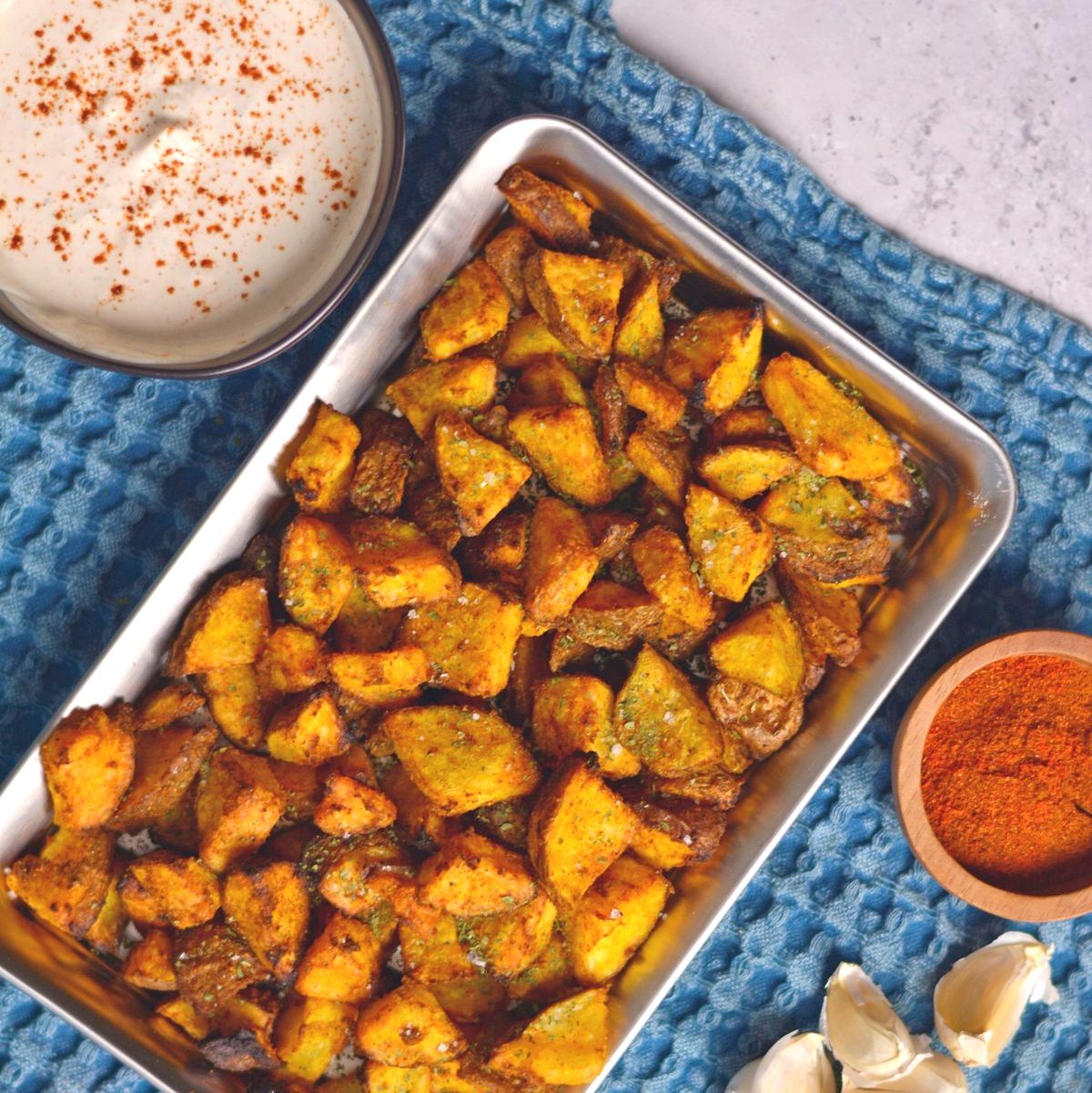 Roasted Potato pieces in a square metal tray.