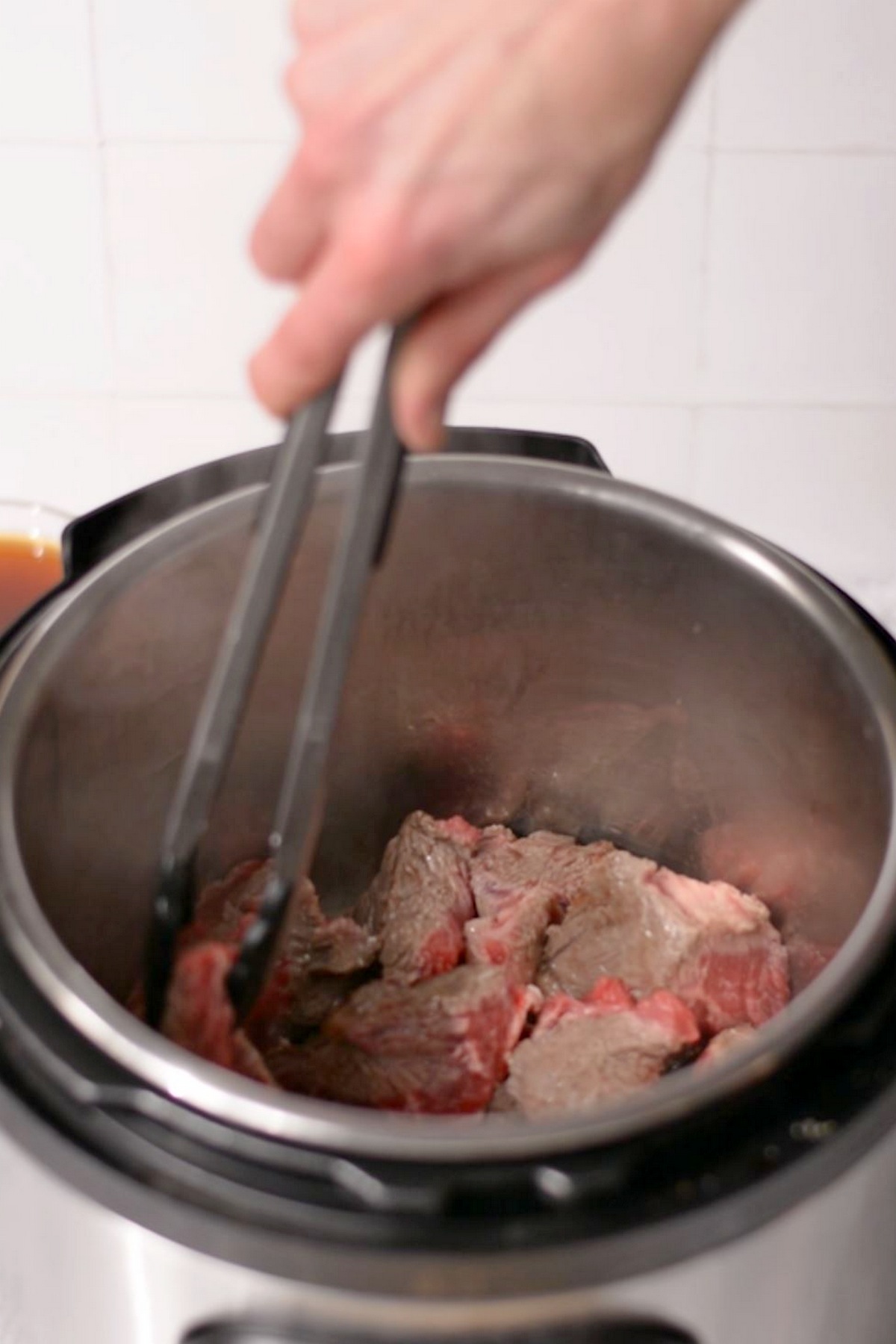 Sautéing beef chunks in an Instant Pot.