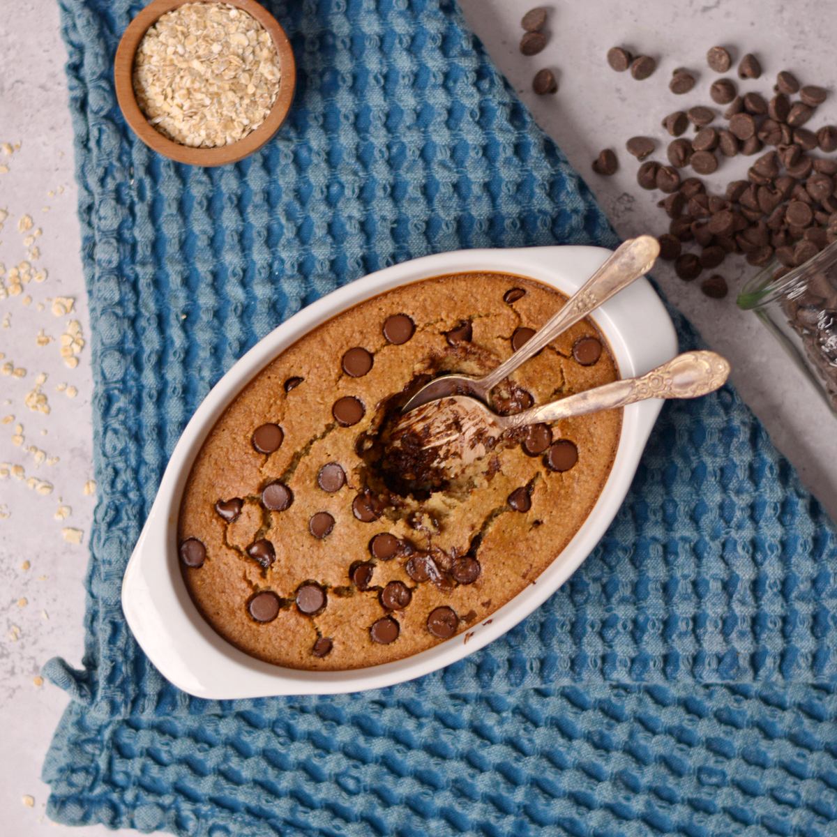Cookie baked oatmeal with a bite taken out with two spoons.