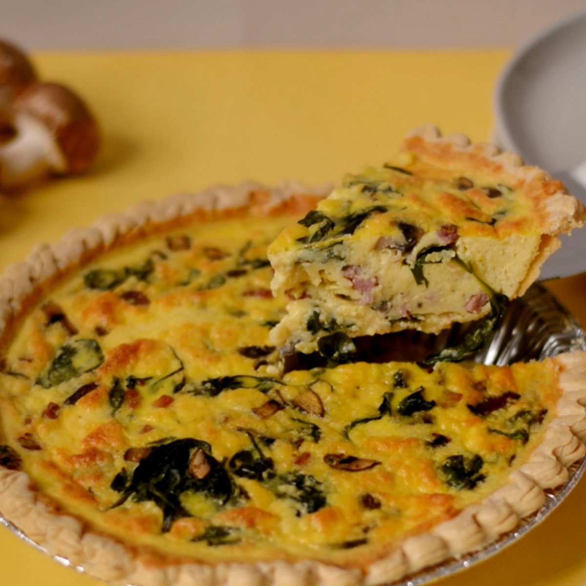 A slice of quiche being taken out of the pan.