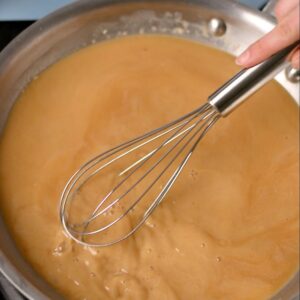 Whisking gravy in a pan.