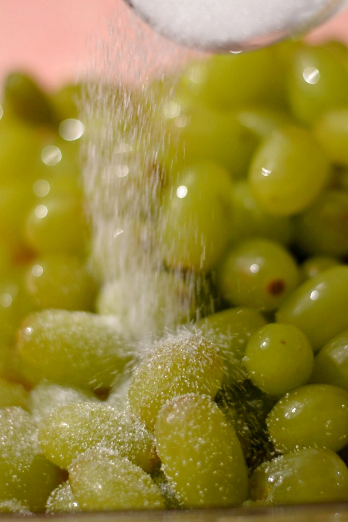Sugar being poured into grapes.