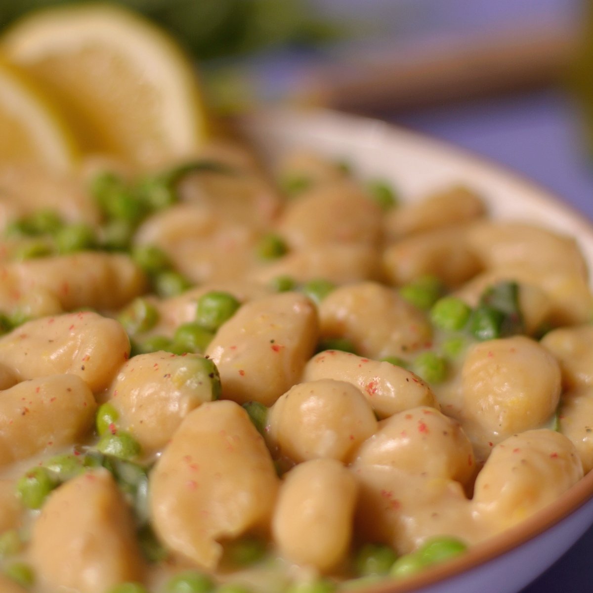 A plate of gnocchi and peas close up.