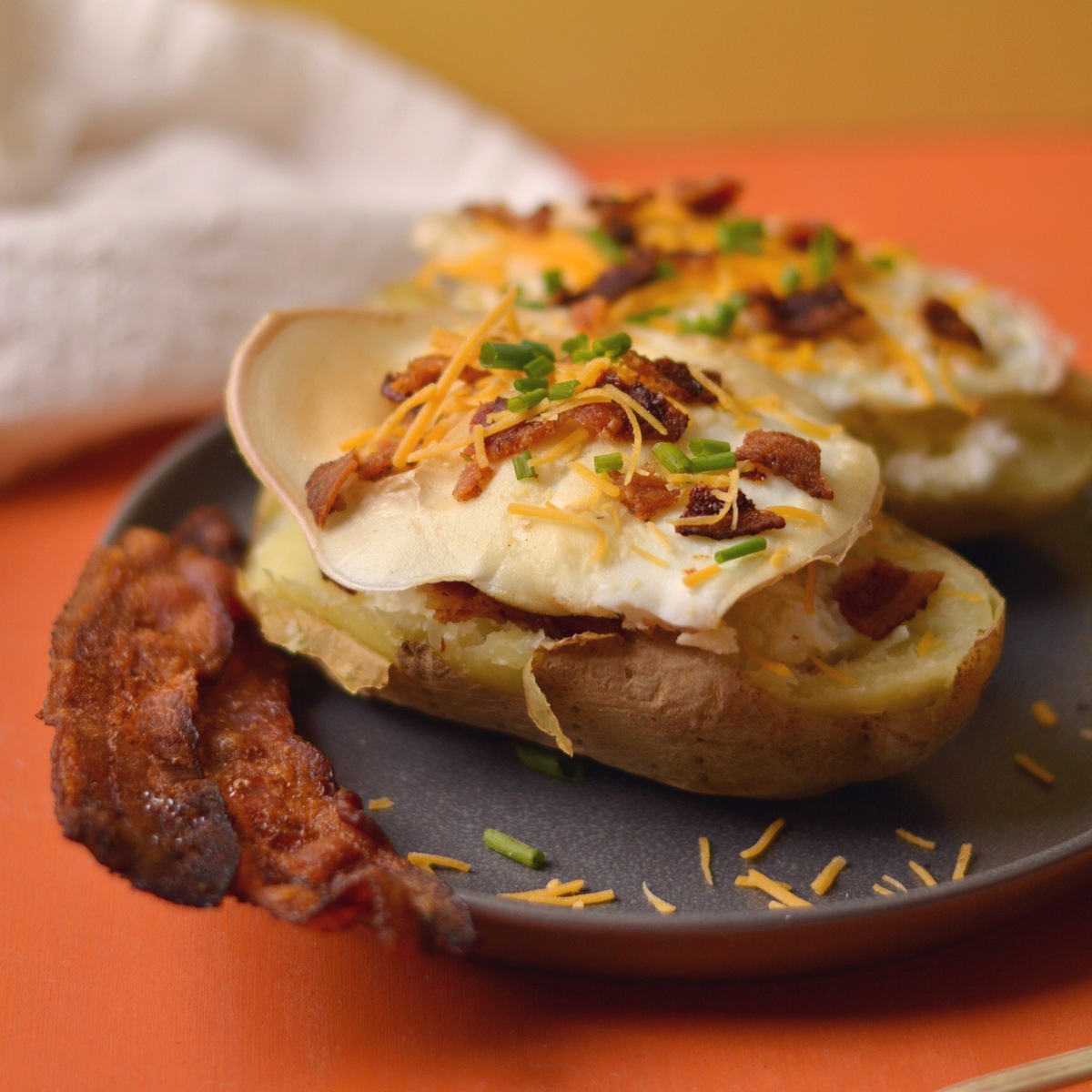 Russet baked breakfast potato with an egg and bacon on top.