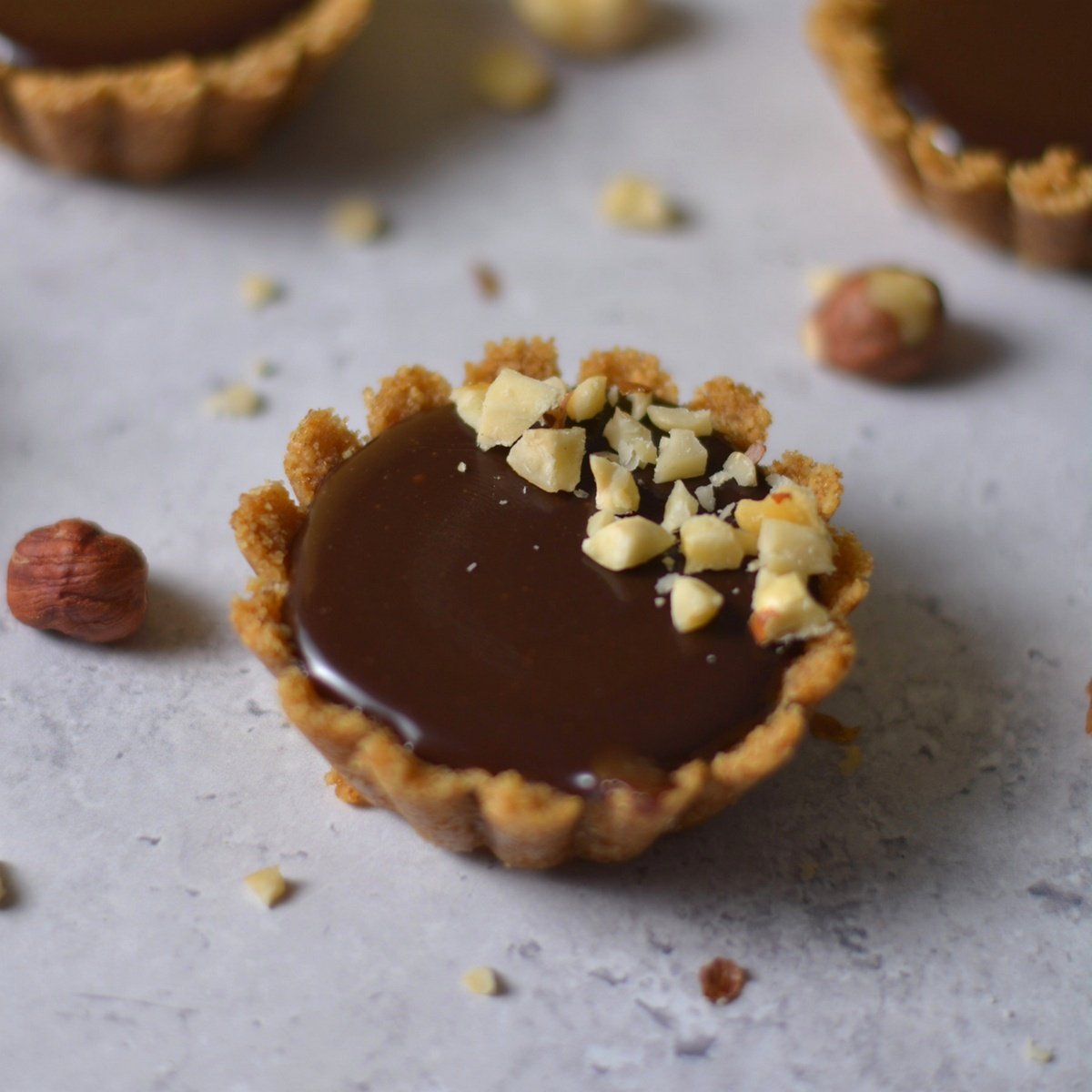 A nutella tartlet with chopped hazelnuts on top.