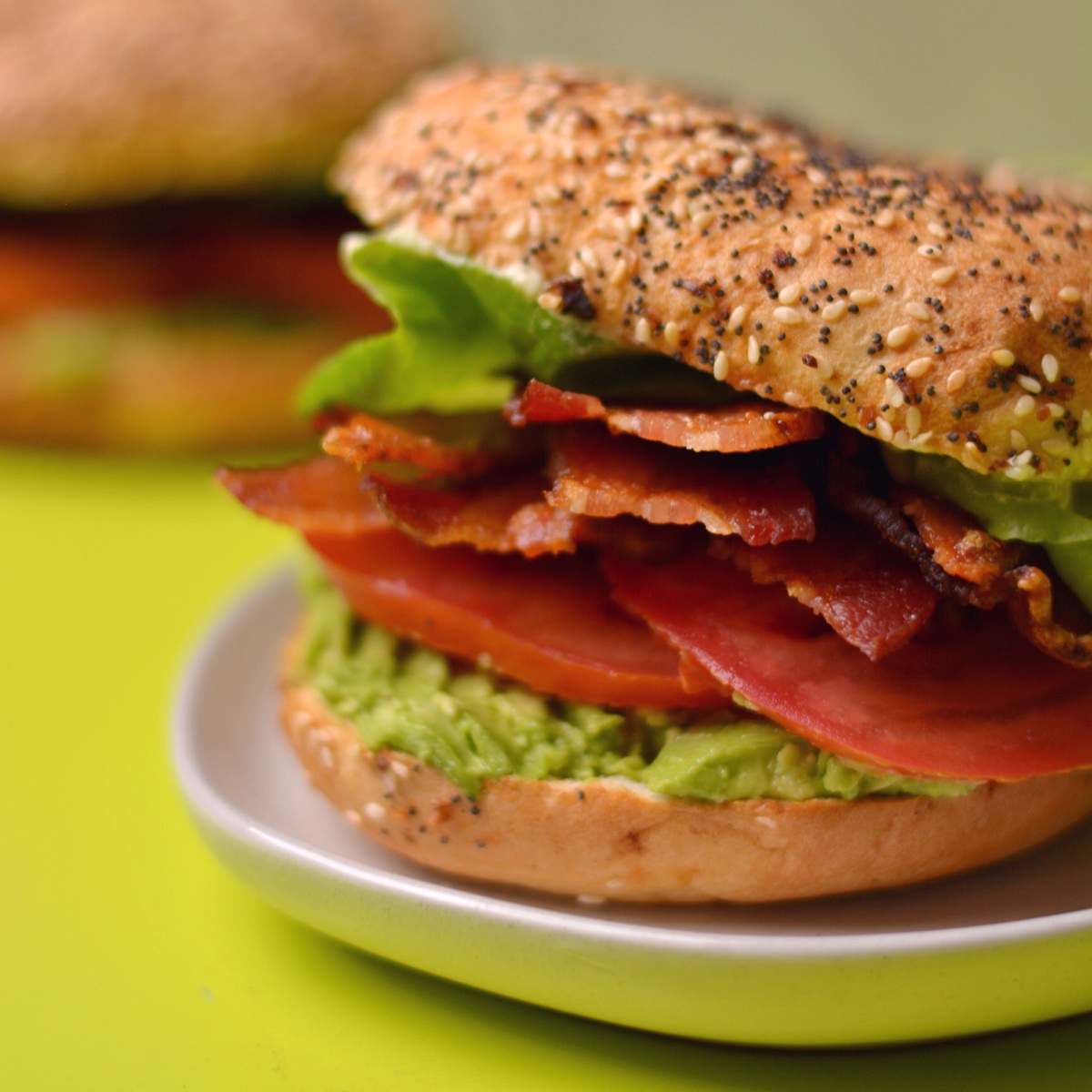 A bagel blt showing bacon and other layers.