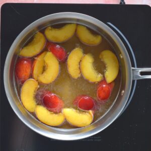 Peaches cooking in a saucepan.