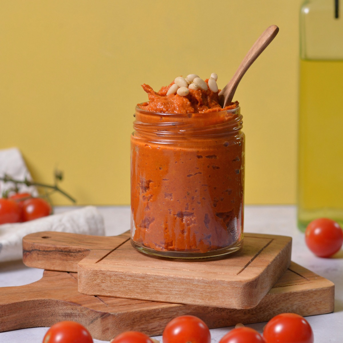 Side view of red pesto in a glass jar.