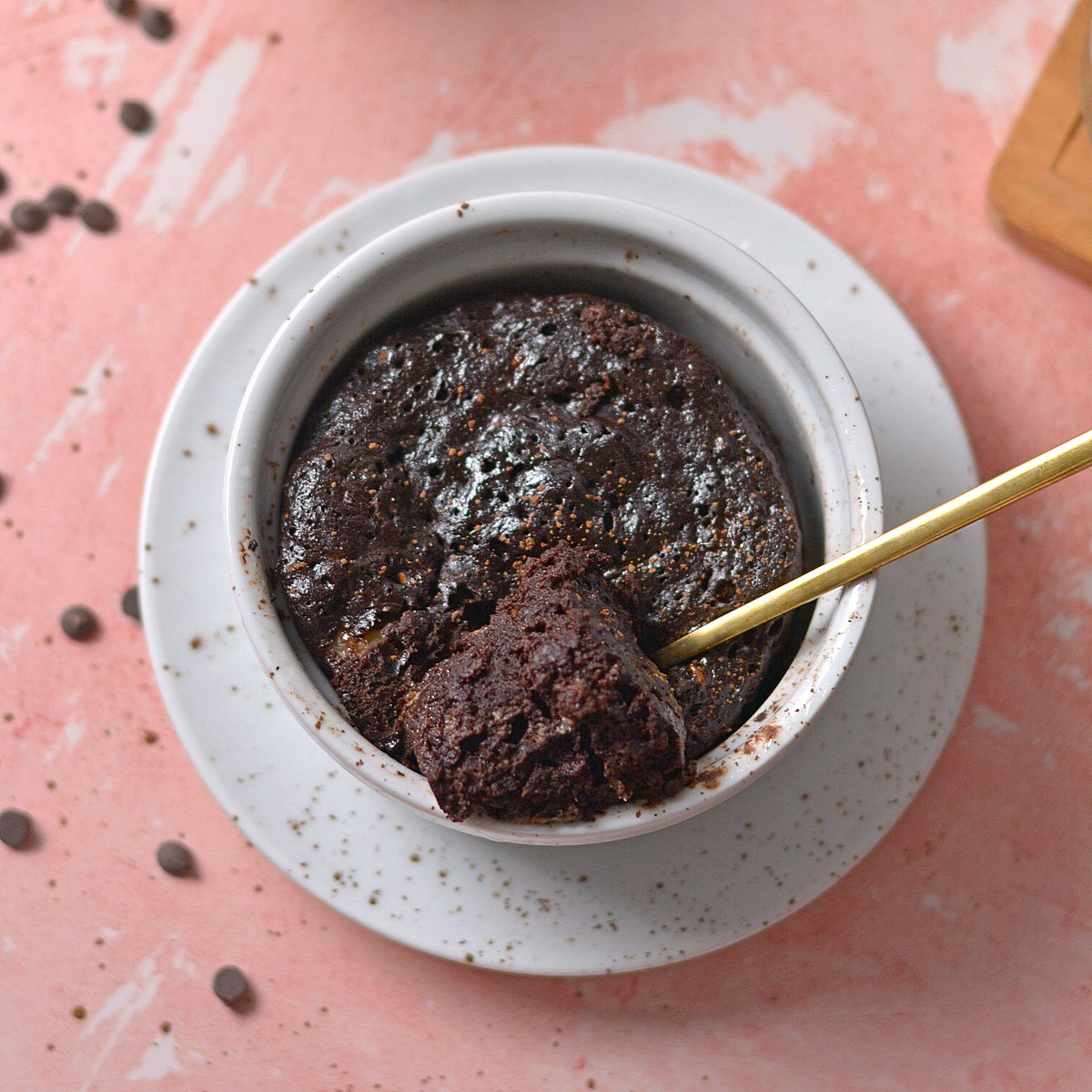 Chocolate banana mug cake with a scoop taken out of it.