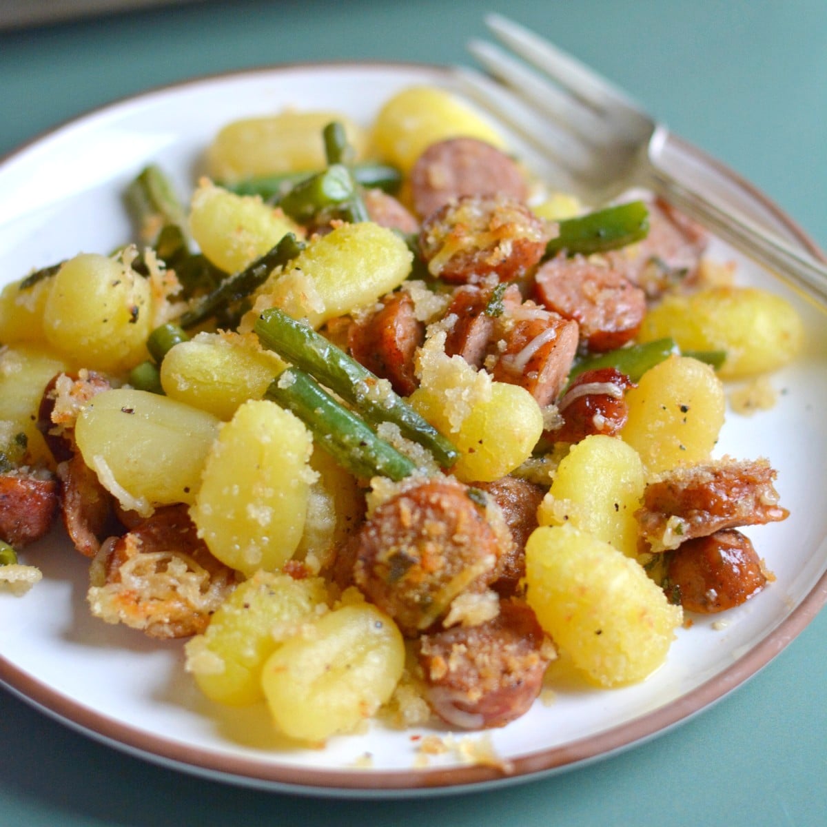 A plate with gnocchi on it and the sheet tray behind.