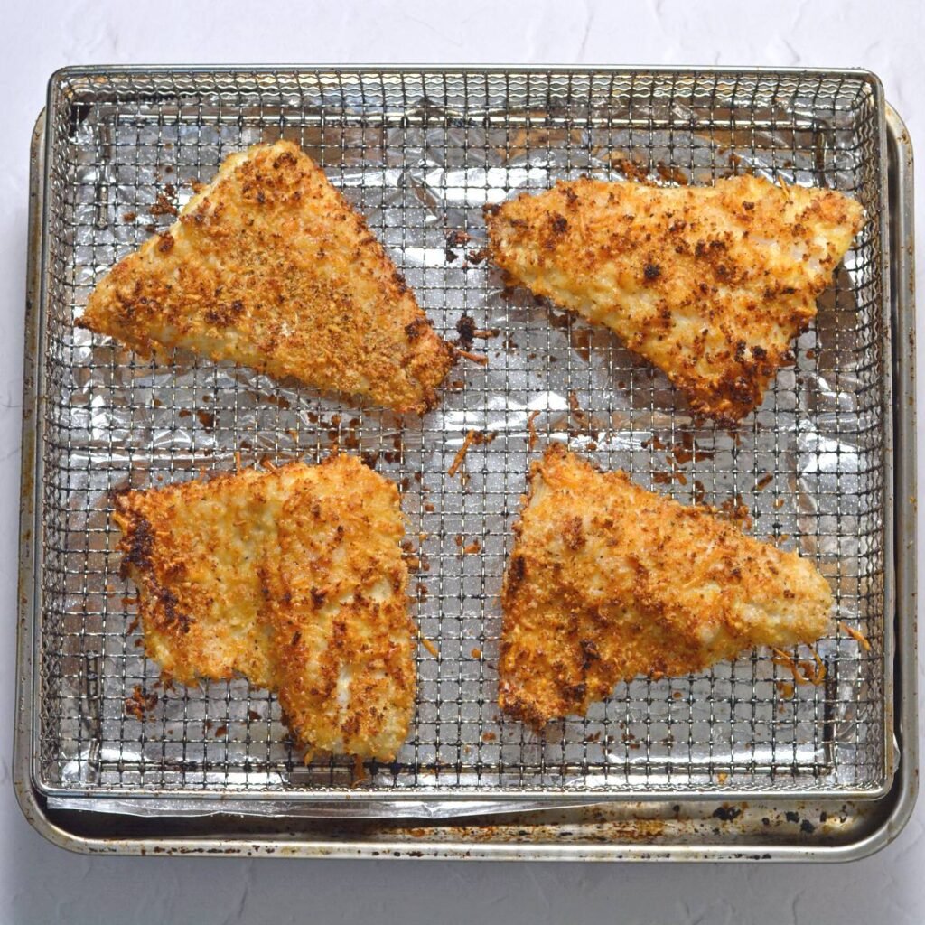 Walleye fillets in an air fryer basket after frying.