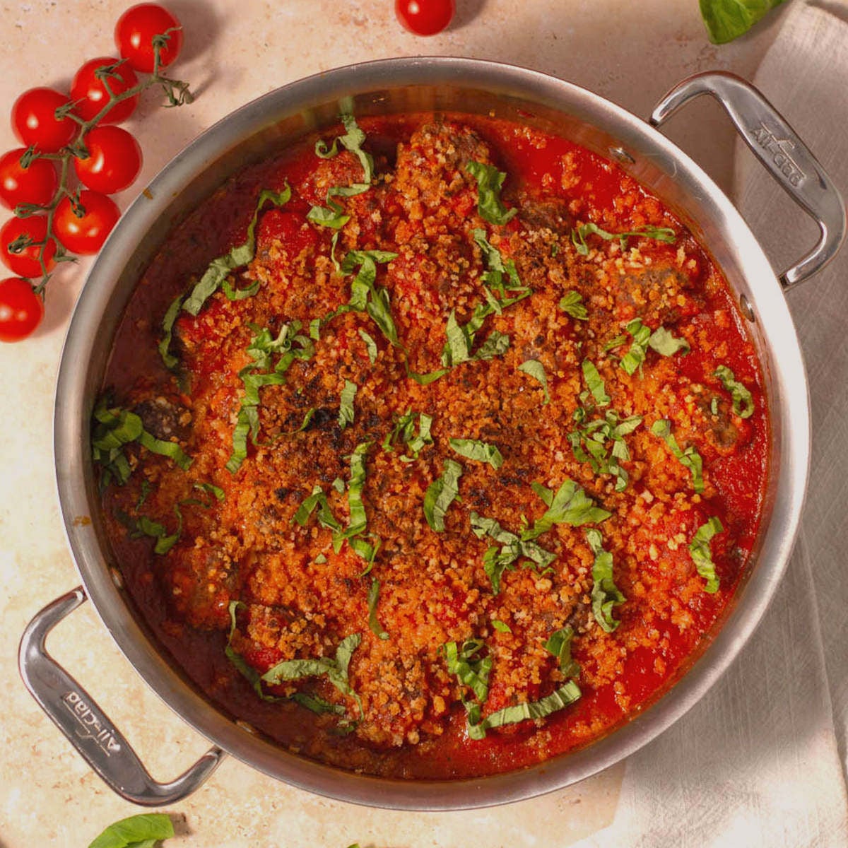Cottage cheese meatballs in red sauce in a metal pot.