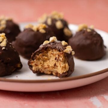 Peanut butter truffle on a plate with a bite taken out.