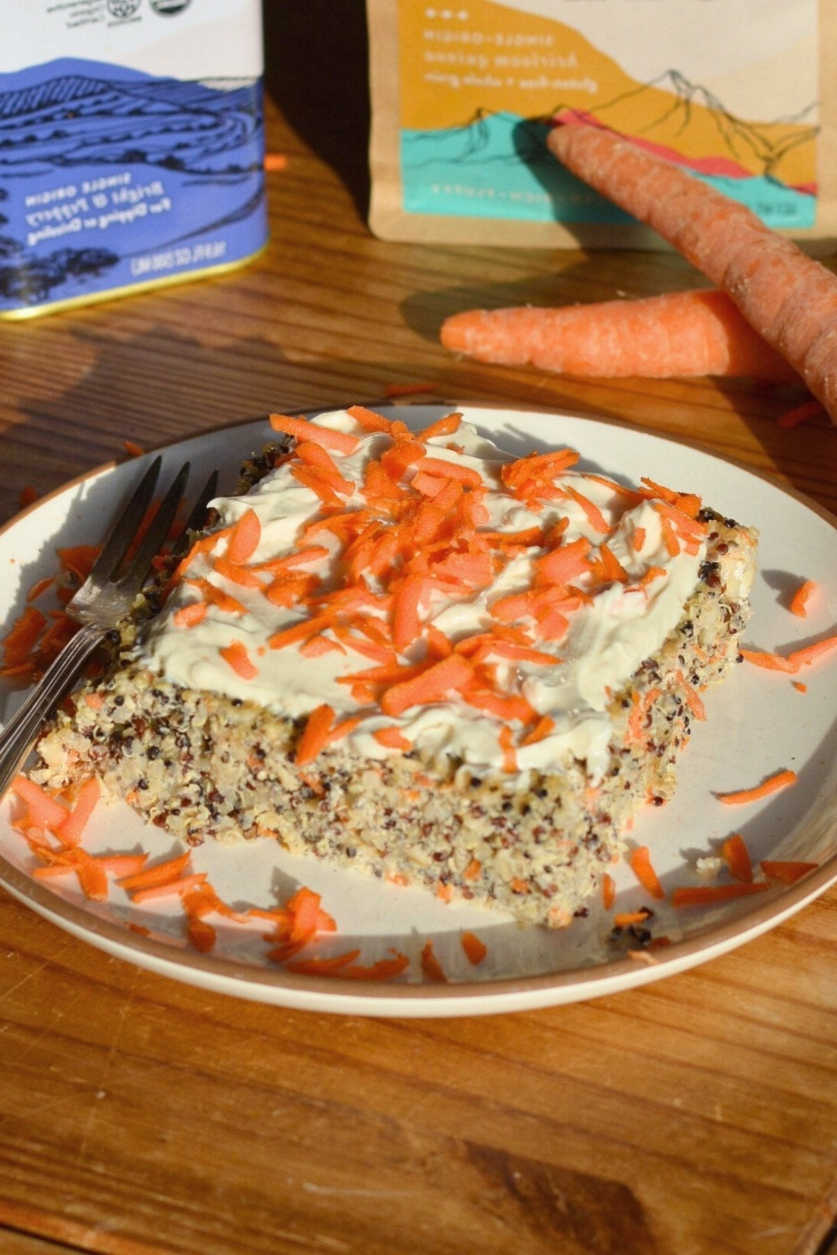 A piece of carrot cake baked oatmeal and quinoa with yogurt and shredded carrots on top.
