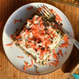 A piece of carrot cake baked oatmeal and quinoa with yogurt and shredded carrots on top.