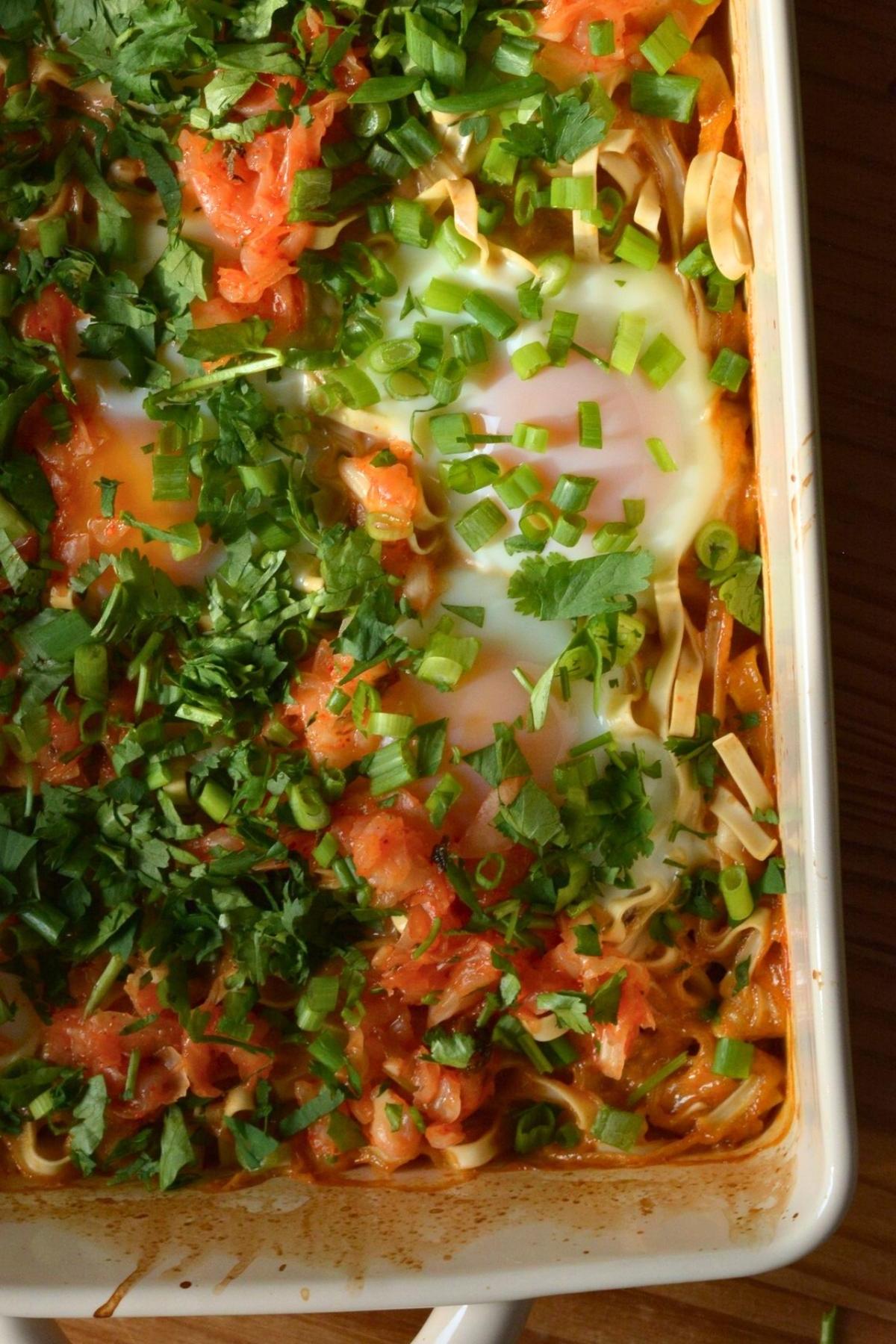 A dish of protein peanut ramen noodles with an egg and diced green onion.